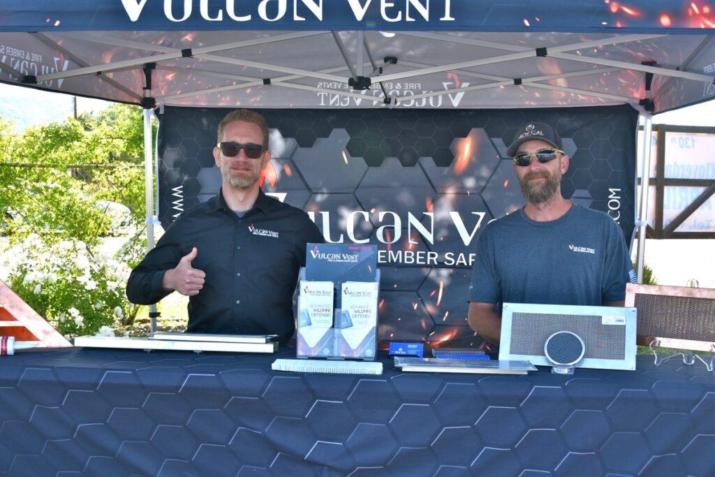 Two representatives at their exhibitor booth during a previous Expo are ready to share information about Vulcan Vent, covers for building foundation and other air vents designed to keep embers from passing through during a fire.